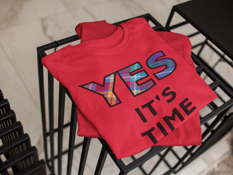 YES-TARTAN-mockup-of-a-folded-pair-of-t-shirts-on-top-of-furniture-indoors-a16945