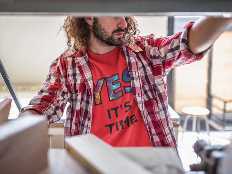 YES-TARTAN-long-haired-carpenter-wearing-a-t-shirt-mockup-at-the-shop-a20172